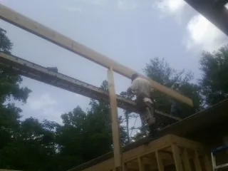 Carpenter setting a ridge beam over a new addition frame — Ice Dam Removal by Roofing Brothers in Warsaw